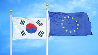 South Korea and European Union two flags on flagpoles and blue cloudy sky